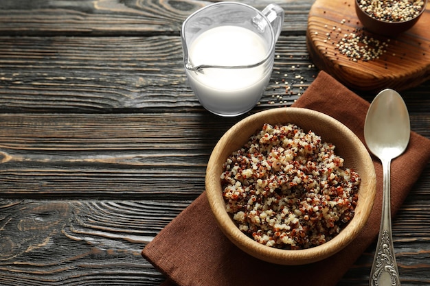 Bol avec des grains de quinoa bouillis sur une table en bois