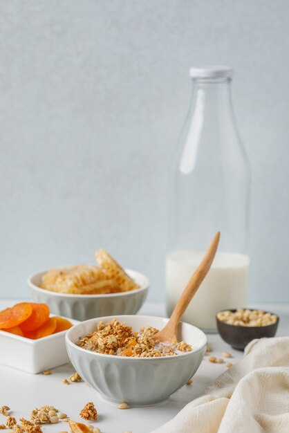 Photo bol de granola avec abricot séché sur table en marbre blanc. cuillère en bois.