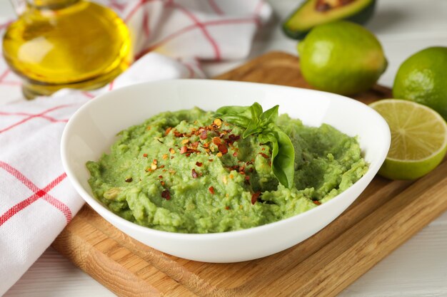 Bol avec guacamole, épices et basilic, gros plan