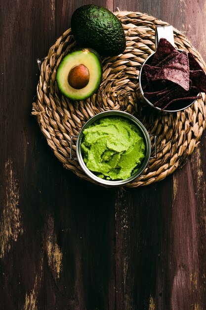 Bol guacamole et nachos sur fond de bois. Vue de dessus