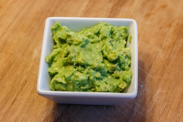 Bol de guacamole sur une table en bois