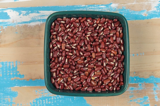 Bol avec des haricots aux yeux noirs sur une table en bois rustique bleue