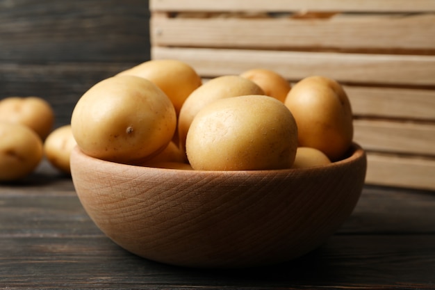 Bol avec jeunes pommes de terre sur une surface en bois