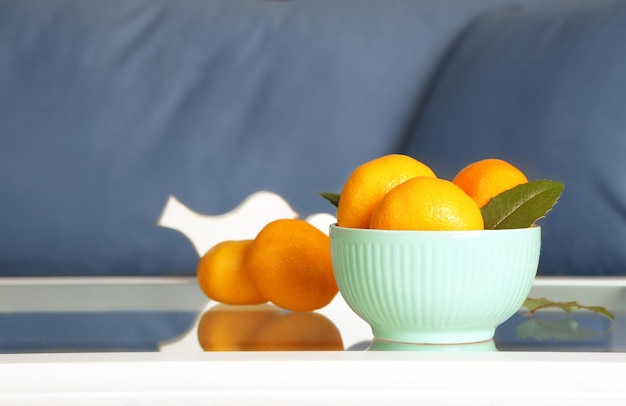 Bol avec des mandarines fraîches sur table dans le salon, gros plan