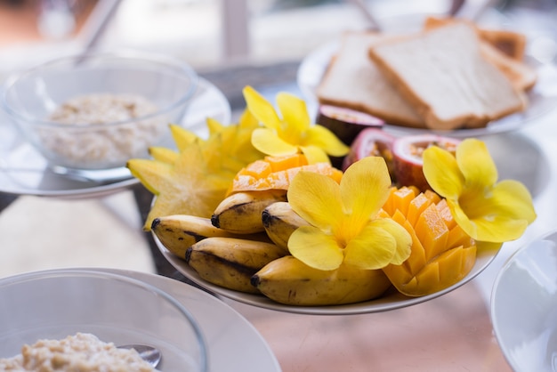 Bol à mangue, banane, fruit de la passion garni de fruits frais et de fleurs