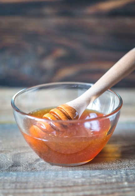 Bol de miel sur la surface en bois sombre