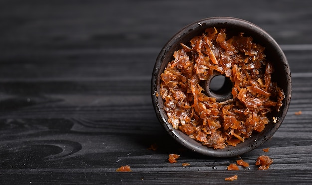 Bol de narguilé avec du tabac et du charbon de bois pour fumer sur un fond sombre espace pour le texte