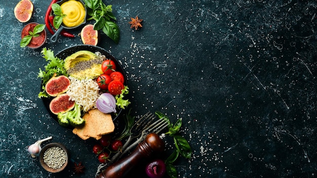 Bol de nouilles bouddha alimentaire avec figues à l'avocat chia et laitue dans une assiette en pierre noire Vue de dessus Espace libre pour votre texte