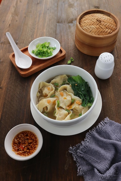 Un bol de nourriture avec une cuillère et un bol de soupe sur une table avec une serviette bleue.