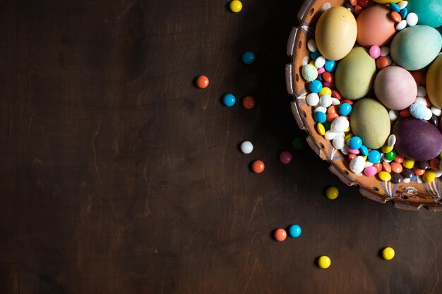 Bol avec des oeufs de Pâques colorés sur une table en bois Espace pour le texte Joyeuses Pâques