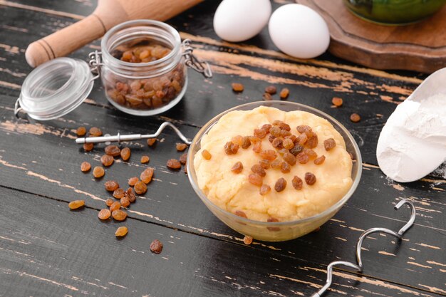 Bol avec pâte sucrée et produits sur table