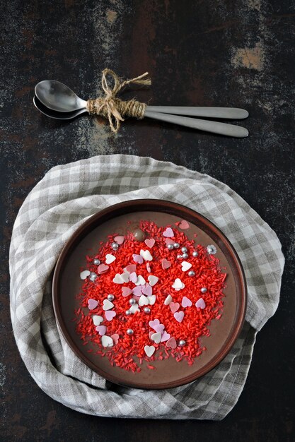 Bol de petit déjeuner de la Saint-Valentin. Petit déjeuner romantique pour la Saint Valentin. Yogourt au chocolat et coeurs de décorations sucrées.