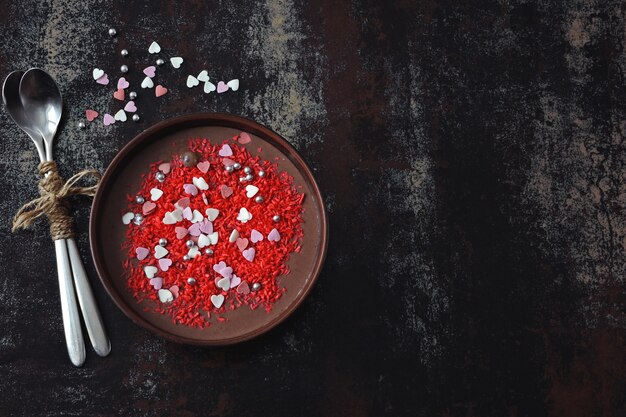 Bol de petit déjeuner de la Saint-Valentin. Petit déjeuner romantique pour la Saint Valentin. Yogourt au chocolat et coeurs de décorations sucrées.