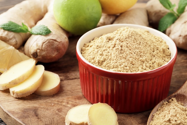 Un bol plein de gingembre sec, avec du gingembre frais, du citron et de la menthe.