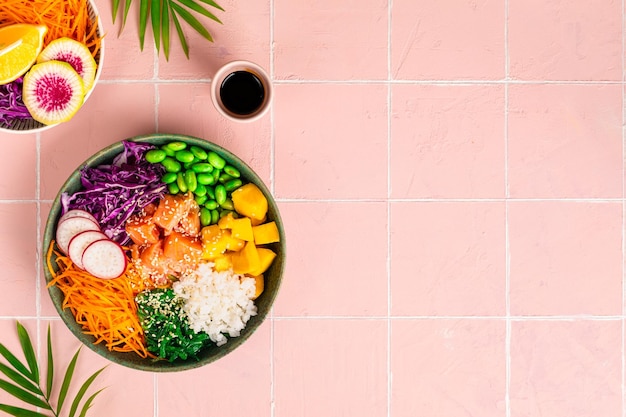 Bol de poke hawaïen au saumon dans un bol avec des graines de sésame aux algues et du chou Vue de dessus mise à plat