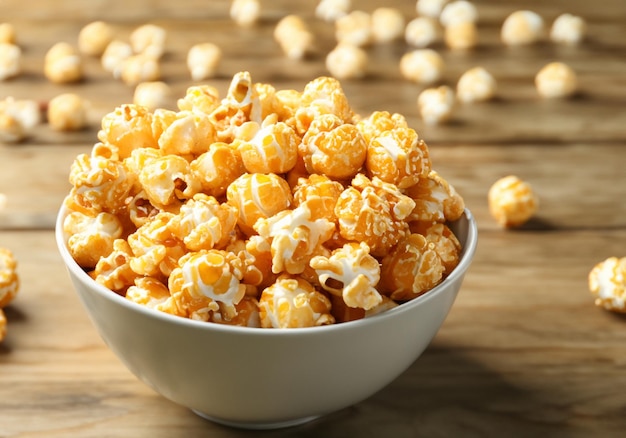 Un bol de pop-corn au caramel sur une table en bois.