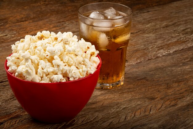 Bol avec pop-corn salé et soda sur la table