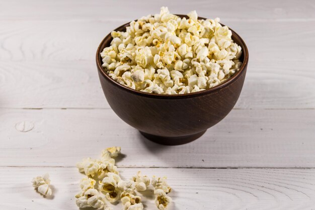 Bol avec pop-corn sur table en bois blanc