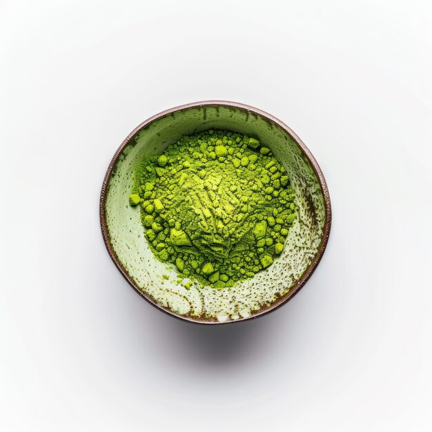 Un bol de poudre de matcha vert vibrant sur une surface blanche