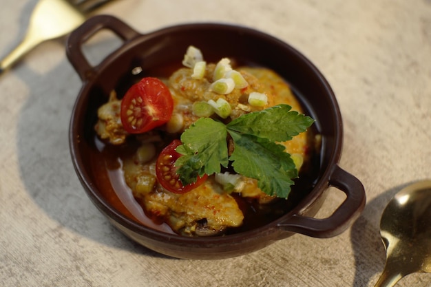 Photo un bol de poulet au curry avec une tranche de tomate et du céleri sur le dessus