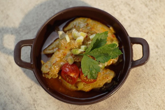 Photo un bol de poulet au curry avec une tranche de tomate et du céleri sur le dessus