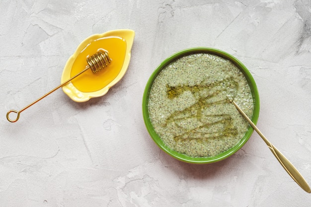 Bol de pudding aux graines de chia au thé vert Matcha avec du miel. Concept de super-aliments et végétalien.