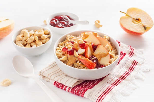 Bol de quinoa au beurre d'arachide et aux pommes avec confiture et noix de cajou pour un petit-déjeuner sain