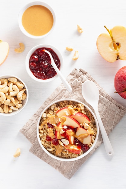 Bol de quinoa au beurre d'arachide et aux pommes avec confiture et noix de cajou pour un petit-déjeuner sain