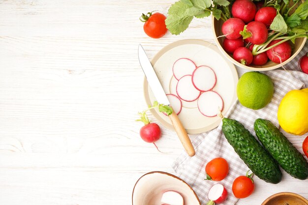 Bol avec radis et autres légumes de printemps sur un espace de fond en bois pour la vue de dessus de texte