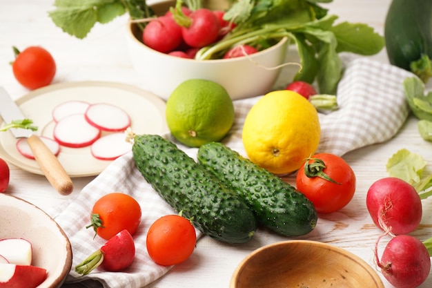 Bol avec radis et autres légumes de printemps sur un gros plan de fond en bois