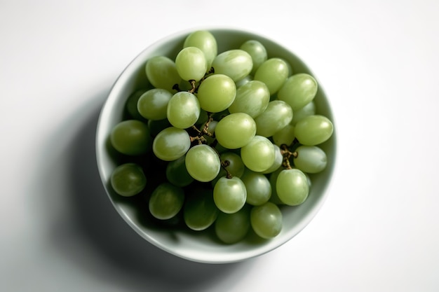 Un bol de raisins est sur une table blanche.