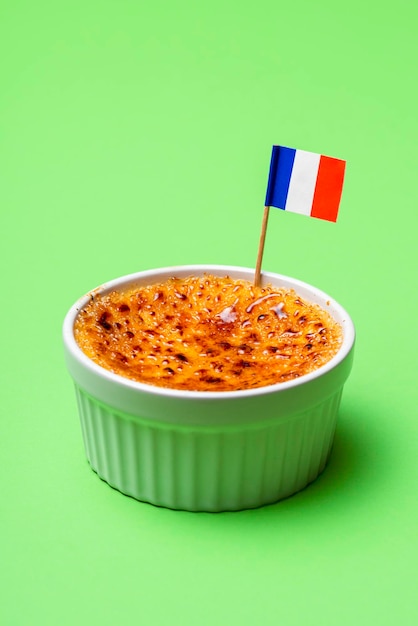 Bol de ramequins avec crème brûlée sur fond vert Recette française de crème brûlée