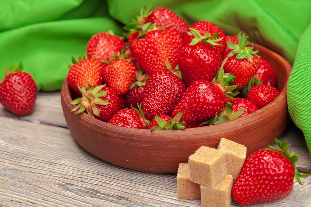 Bol de récolte de fraises sur table en bois se bouchent