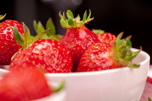 Bol de récolte de fraises sur table en bois