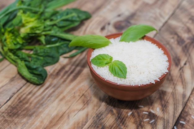 Bol de riz au basilic laisse sur une table en bois