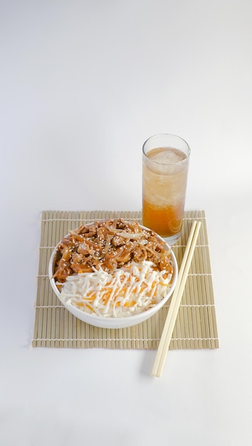 bol de riz au poulet tranché et sauce aux huîtres accompagné d'un verre de thé glacé