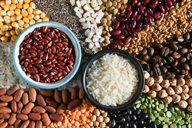 Bol avec riz blanc cru et haricots sur divers grains de graines