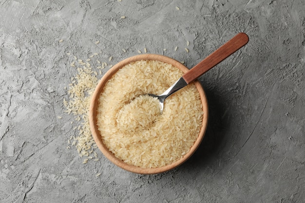 Bol avec riz et cuillère sur surface grise