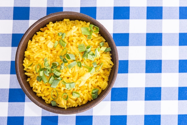 Bol de riz jaune sur table bleu et blanc