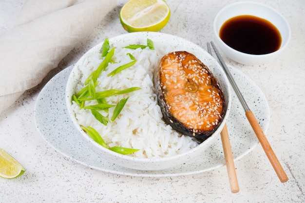 Bol de riz avec steak de saumon teriyaki au four sur fond blanc