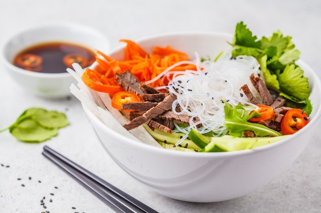 Bol de salade Bun cha. Nouilles de riz vietnamien avec salade de bœuf et de piment dans un bol blanc