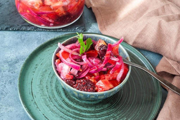 Un bol de salade de chou rouge aux mûres et oignons rouges.