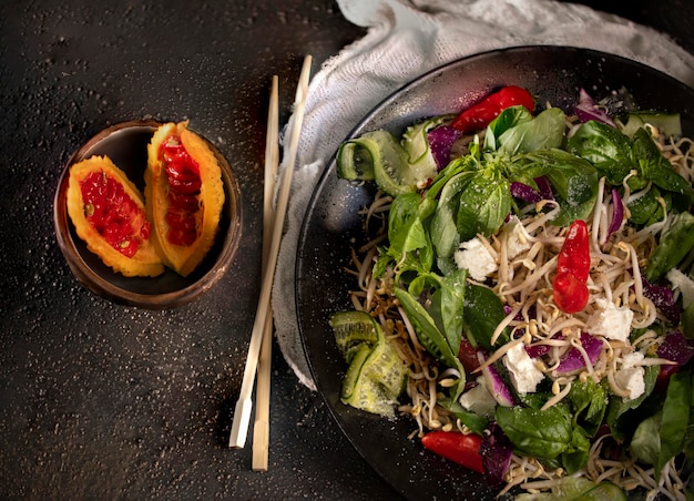 Un bol de salade avec de la feta et un bol de pêches