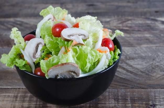 Bol de salade sur fond en bois rustique.