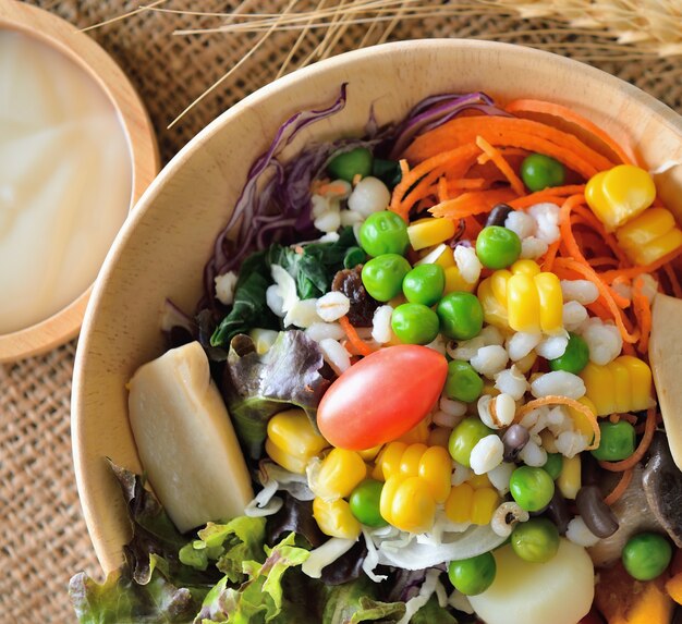 Bol de salade de légumes sur une table en bois