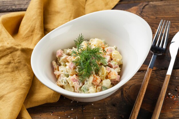 Un bol de salade russe traditionnelle sur une table en bois