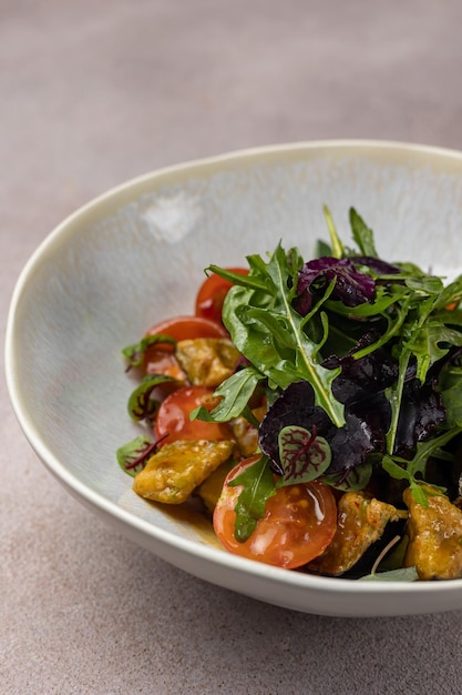 Un bol de salade avec tomates et roquette