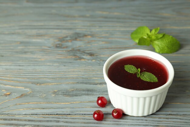 Bol de sauce aux canneberges sur fond de bois gris