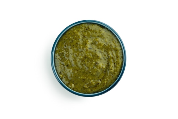 Bol de sauce pesto isolé sur fond blanc