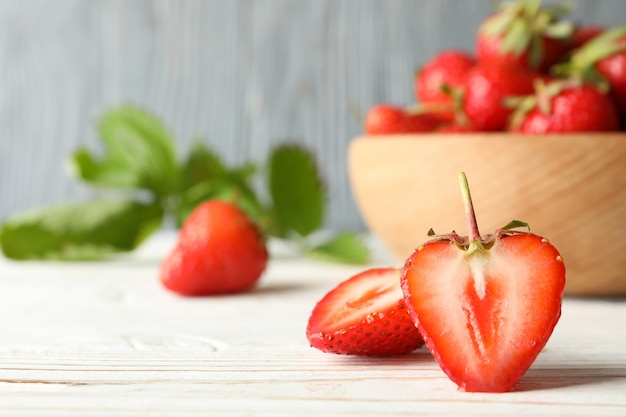 Bol avec savoureuse fraise sur table en bois